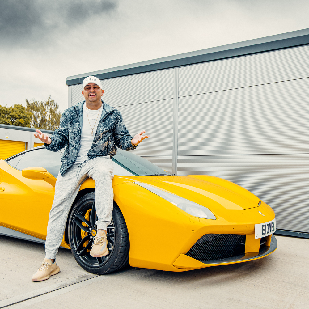 Ste Hamilton leaning against a yellow supercar